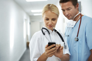 Two young medical professionals looking over information on a smartphone